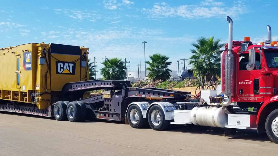 Lone Star truck transporting CAT construction equipment